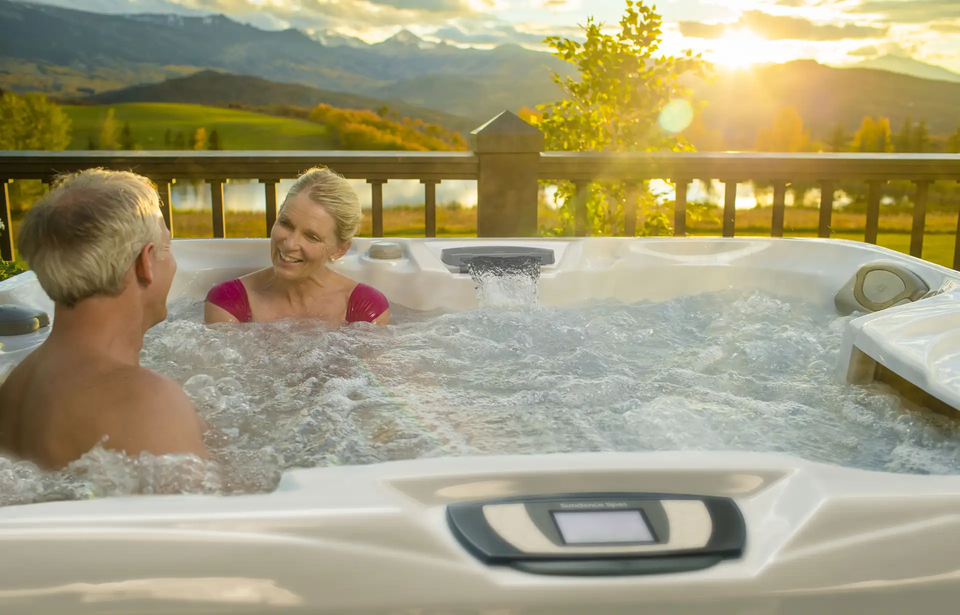 Happy Couple Relaxing In Hot Tub. Sunset